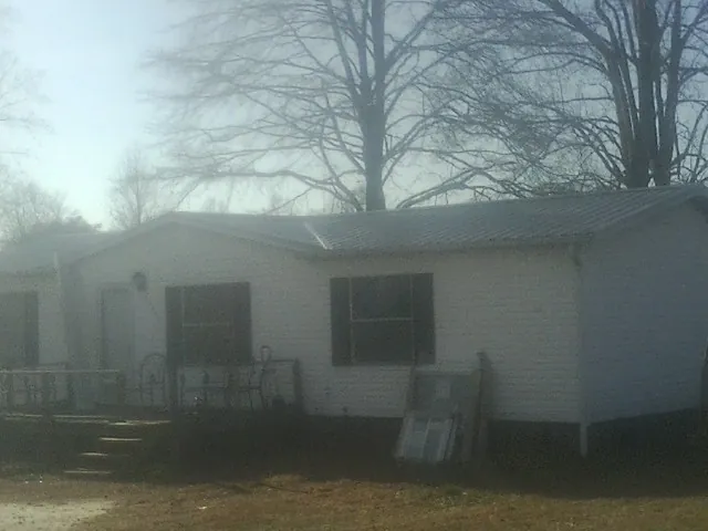 New metal roof on a white painted brick home on a foggy morning in Livingston